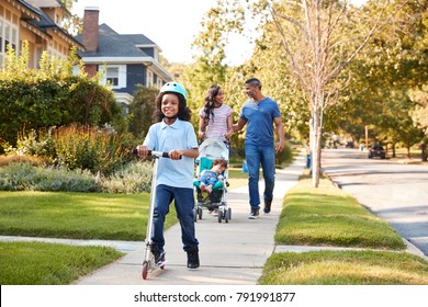 Couple Push Daughter In Stroller As Son Rides Scooter - Shutterstock ID 791991877