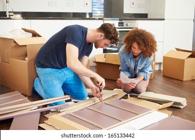 Couple Putting Together Self Assembly Furniture In New Home