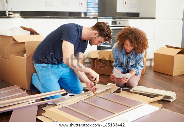 Couple Putting Together Self Assembly Furniture In\
New Home