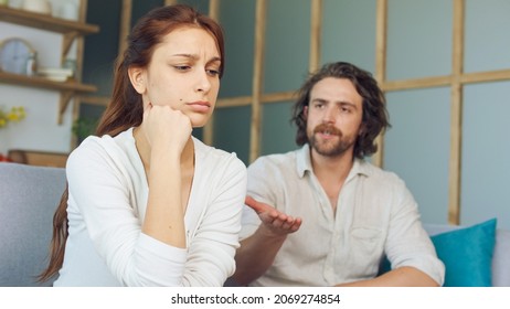 Couple Quarreling Sitting on the Couch at Home, Boyfriend Screams Accusing Girlfriend. Relationship Problems by Reason of Disagreement. The Man and Woman are Arguing. Young Woman Feeling Lonely.