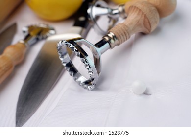 A Couple Of Ravioli Cutters And Other Chef's Tools Of Trade Sitting On A New Chef's Uniform. Could Be Used For Training, School, Hospitality Courses.