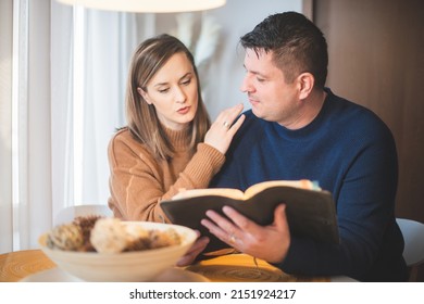 Couple Reading Bible And Pray Together At Home