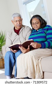 Couple Reading The Bible In Their Home