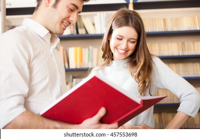 Couple Reading A Book In A Library