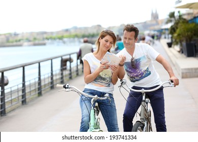 Couple Reading Map On Bike Tour