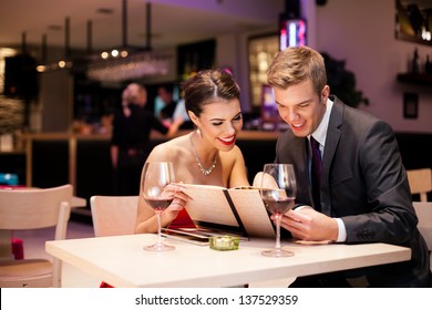 Couple reading  at menu together in a restaurant - Powered by Shutterstock