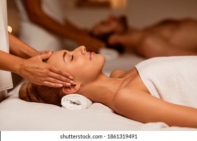 Couple Receiving Acupressure Head Massage Relaxing With Eyes Closed In Luxury Spa Center. Beauty And Relaxation Therapy, Couples Wellness And Rejuvenation Concept. Low Light, Selective Focus