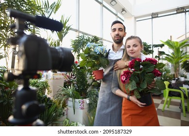 Couple record video for social media content, beautiful photoshot in botanical garden with flowers