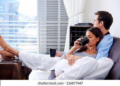 Couple relax at home with cup of coffee and sofa couch. happy healthy relationship