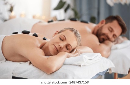 Couple, relax and stone massage in spa for wellness, zen vacation and body pain. Man, woman and hot rock treatment in luxury salon for healing muscle, physical therapy and calm holiday in Thailand - Powered by Shutterstock