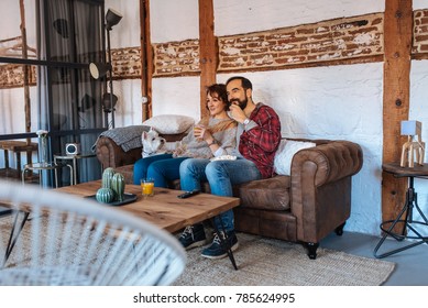 Couple Relaxed At Home In The Couch Watching Tv And Eating Popcorn