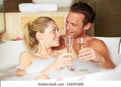 Couple Relaxing In Bath Drinking Champagne Together - Powered by Shutterstock