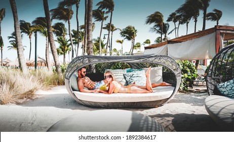 A Couple Relaxing In A Cabana By The Pool