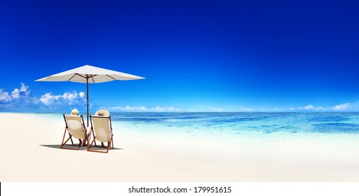Couple Relaxing in Deck Chairs on Tropical Beach