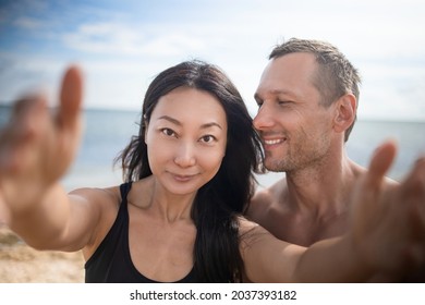 Couple relaxing on beach taking selfie picture with camera smartphone. Young multiracial couple on getaway vacation in Hawaii lying down looking at camera. Candid closeup angle looking candid real. - Shutterstock ID 2037393182