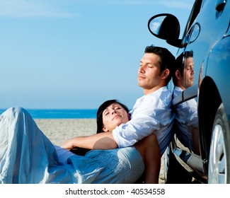 Couple relaxing on car on the beach