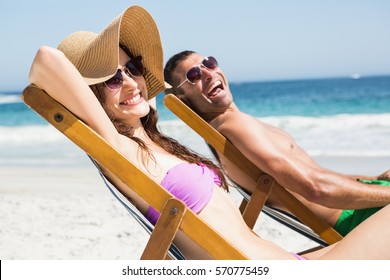 Couple relaxing on deck chair on the beach