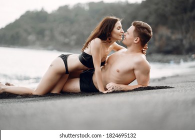 couple relaxing at a secluded private beach in Bali Indonesia. couple showing affection on a hidden beach. Couple wearing bathingsuits - Powered by Shutterstock