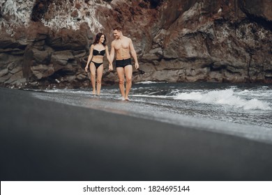 couple relaxing at a secluded private beach in Bali Indonesia. couple showing affection on a hidden beach. Couple wearing bathingsuits - Powered by Shutterstock