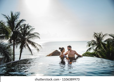 Couple relaxing in a swimming pool - Powered by Shutterstock