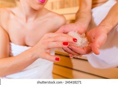Couple relaxing together in wellness spa sauna with ice to cool down
