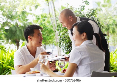 Couple In Restaurant, Man Giving Waiter Credit Card