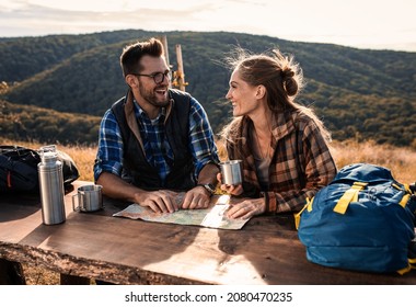 Couple resting after hiking looking for new direction on map. - Powered by Shutterstock