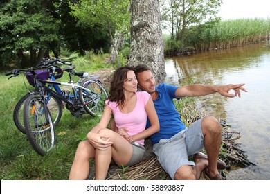 Couple Resting By A Lake