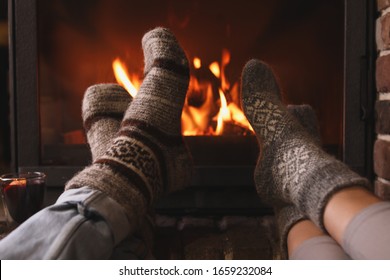 Couple resting near fireplace indoors, closeup. Winter vacation - Powered by Shutterstock