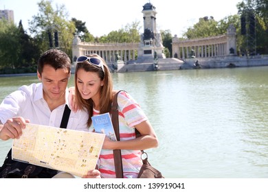 Couple In Retiro Park Of Madrid Looking At Map