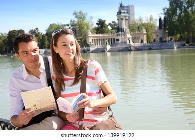 Couple In Retiro Park Of Madrid Looking At Map