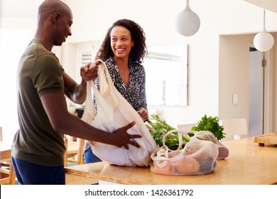 Couple Returning Home From Shopping Trip Unpacking Plastic Free Grocery Bags - Powered by Shutterstock