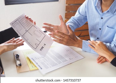 Couple Reviewing House Plan And Layout With A Real Estate Company Before Making Final Decision To Buy Their New Property. Business Negotiation And Discussion Between Vendor And Customers Concept