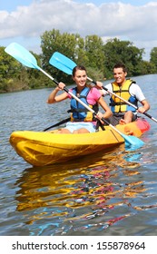 Couple Riding Canoe In River