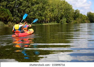 Couple riding canoe in river