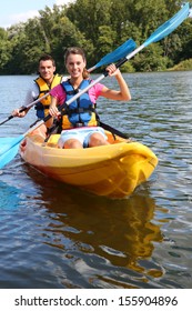 Couple Riding Canoe In River