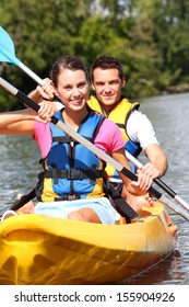 Couple Riding Canoe In River