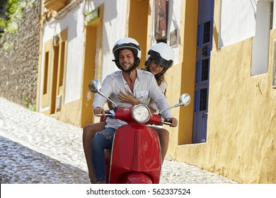 Couple Riding Motor Scooter In Old Ibiza Street, Close Up