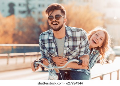 Couple Riding Their Bikes In Their Free Time And Having Fun On A Sunny Summer Day.