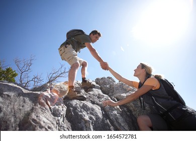 Couple Rock Climbing Together On A Sunny Day