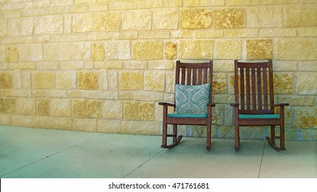 A Couple Of Rocking Chairs By Yellow Stone Wall