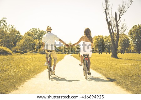Couple of romantic lovers cycling - caucasian people - people, love, nature and lifestyle concept
