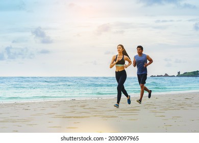 Couple runner jogging athletes at the beach with cloudy sky. - Powered by Shutterstock