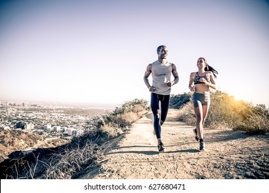 Couple of runners training outdoors - Two sportive people running - Powered by Shutterstock