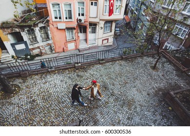 Couple Running By Old European Street With Paving Stones, Top View