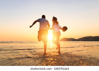 couple running and hand hold on the beach between sunset. - Powered by Shutterstock