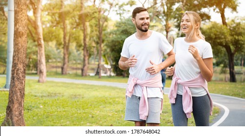 Couple Are Running Happy In The Garden. Family Workout Activity During The Holiday. Safe And Clean Exercise Places For The Health Of People Who Use The Place. Concept Sport Health