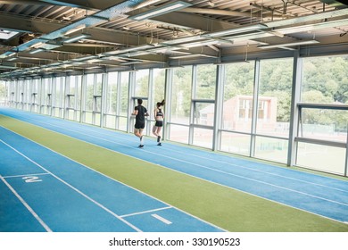 Couple Running On The Indoor Track At The Gym