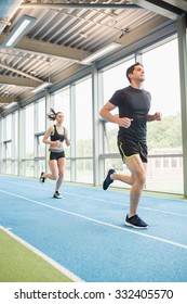 Couple Running On The Indoor Track At The Gym