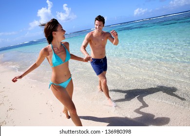 Couple Running On A Sandy Beach